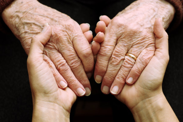 Hände einer jungen und einer alten Person ineinander